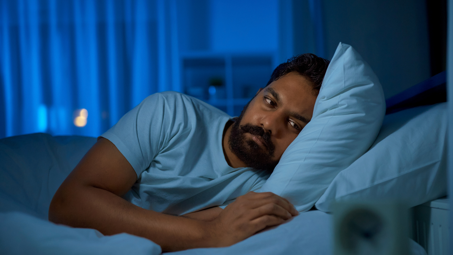 Man lying awake on his bed